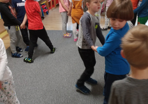 dzieci stojąw parach na dywanie i uczestniczą w zabawie ruchowej