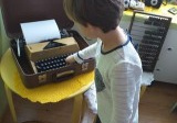 dziewczynka ogląda starą maszynę do pisania