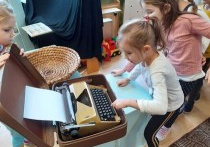 dziewczynka wciska klawisze maszyny do pisania
