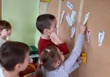 dzieci przypinają na tablicy pokolorowane klucze
