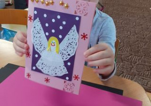 dziewczynka prezentuje kartkę z aniołkiem z serwetki