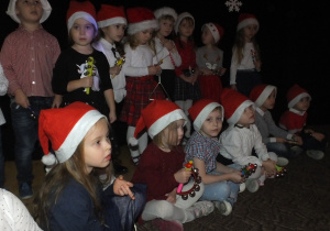 grupa dzieci śpiewa Mikołajowi piosenkę