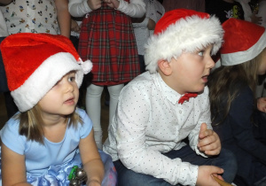 chłopiec i dziewczynka śpiewają Mikołajowi piosenkę