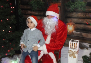 chłopiec siedzi na kolanach Mikołaja
