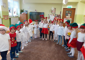 dzieci w czapeczkach elfów spiewają po angielsku świąteczne piosenki