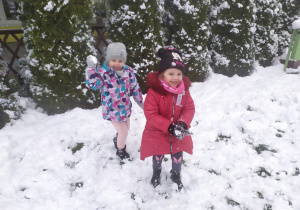 dwie dziewczynki bawią się na śniegu