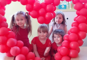 kilka dziewczynek pozuje do zdjęcia w sercu z balonów