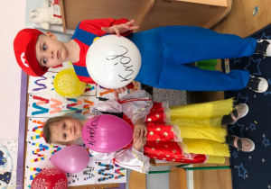 chłopiec i dziewczynka trzymają balony z napisem: królowa i król