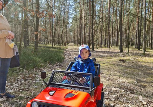 chłopiec w lesie w samochodziku