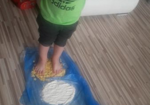 chłopiec chodzi boso po ziarenkach zbóż