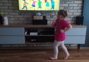 dziewczynka tańczy przed telewizorem