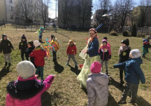 grupa dzieci tańczy w przedszkolnym ogrodzie, uczestniczy w powitaniu wiosny