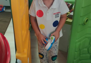 chłopiec w koszylce z kropki stoi w drzwiach domu do zabawy