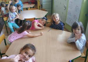 grupa dziec isiedzi przy stolikach w klasie, oglądają historię o Vashti na tablicy multimedialnej