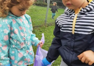 chłopiec i dziewczynka na dworze, dziewczynka trzyma worek na śmieci