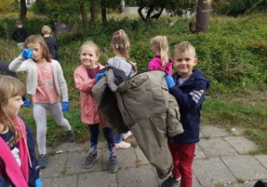 grupa dzieci pokazuje znalezioną kurtkę