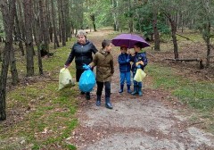 las, babcia z trzema wnukami idzie leśną drogą, wszyscy trzymają worki ze śmieciami