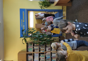 grupa dzieci w bibliotece, zwiedzają pomieszczenie, gdzie zgromadzony jest księgozbiór