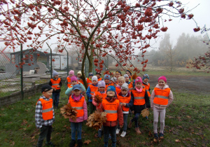 dzieci stoją pod jesiennym drzewem