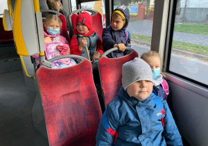 pięcioro dzieci w maseczkach siedzi w autobusie