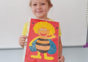 dziewczynka prezentuję swoją pracę "Pszczółka Maja"