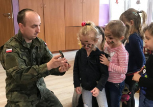 żołnierz maluje grupę dzieci