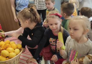 dzieci częstują się owocami