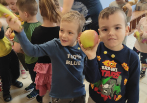 dzieci pokazują otrzymane za elektrosmieci owoce