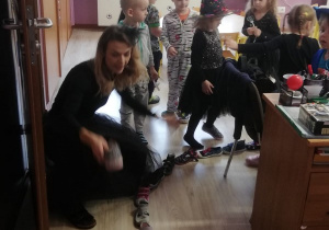 nauczycielka przebrana za czarownicę układają buty jeden za drugim