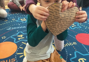 chłopiec przebuja papierowe serce wróżąc imię swojej wybranki