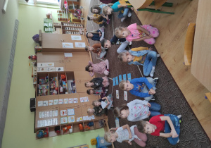 dzieci siedzą na podłodze oglądają bajkę po angielsku