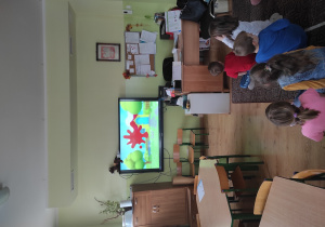 dzieci siedzą na podłodze oglądają bajkę po angielsku