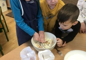 trzech chłopców miesza produkty spożywcze w misce