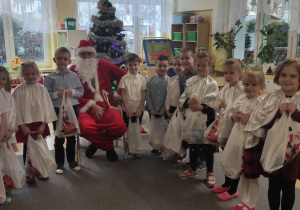 Grupa dzieci pozuje do zdjęcia z Mikołajem