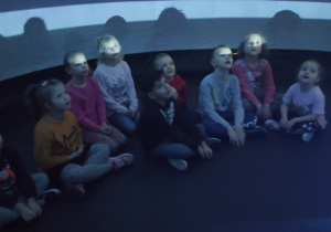 grupa dzieci w namiocie - planetarium ogląda film edukacyjny
