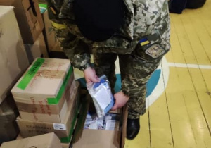 ukraiński żołnierz otwiera kartony otrzymane z Ozorkowa
