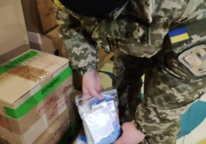 ukraiński żołnierz otwiera kartony otrzymane z Ozorkowa