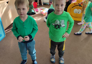dzieci w klasie, na pierwszym planie dwaj chłopcy ubranaz ubrania koloru zielonego