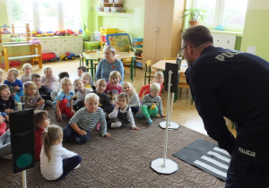 grupa dzieci na spotkaniu z policjantem