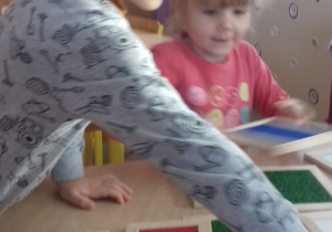 chłopiec i dziewczynka układają domino dotykowe