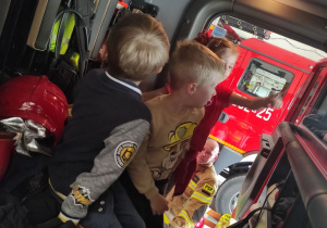 dwóch chłopców w wozie strażackim