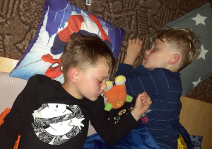 dwaj chłopcy śpią w śpiworach w klasie