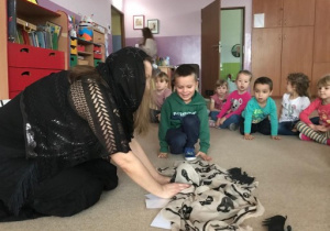 czarownica i dzieci siedzą na dywanie