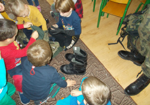 dzieci przymierzają wojskowe buty