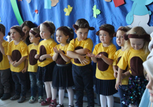Grupa dzieci w strojach misiów śpiewa piosenkę.