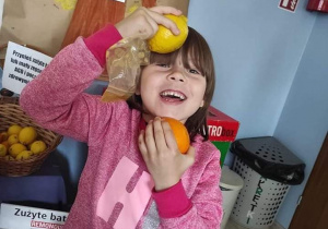 uśmiechnięta dziewczynka pozuje do zdjęcia z owocami