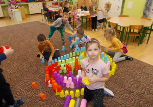 grupa dzieci układa konstrukcje z kolorowych kubeczków