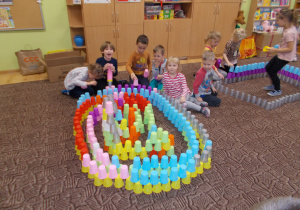 grupa dzieci układa konstrukcje z kolorowych kubeczków