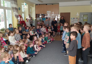 Chłopcy stoją przed dziewczynkami i Paniami- śpiewają piosenkę i składają życzenia z okazji Dnia Kobiet.