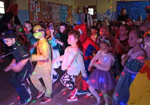 Dzieci przebrane w różne postaci, tańczą w przedszkolnej szatni